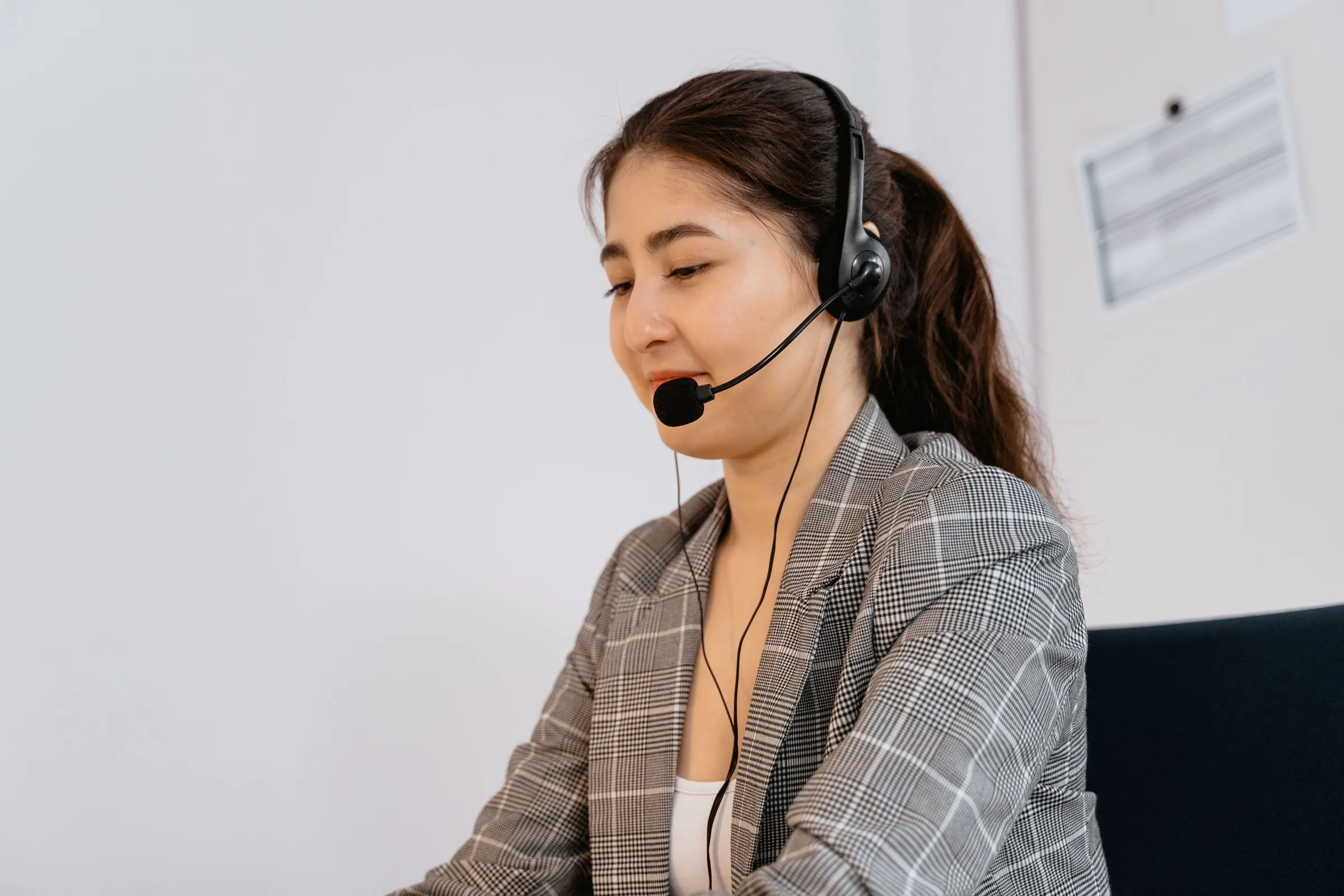Una agente con auriculares atiende una llamada